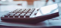 Calculator sitting on a stack of papers.