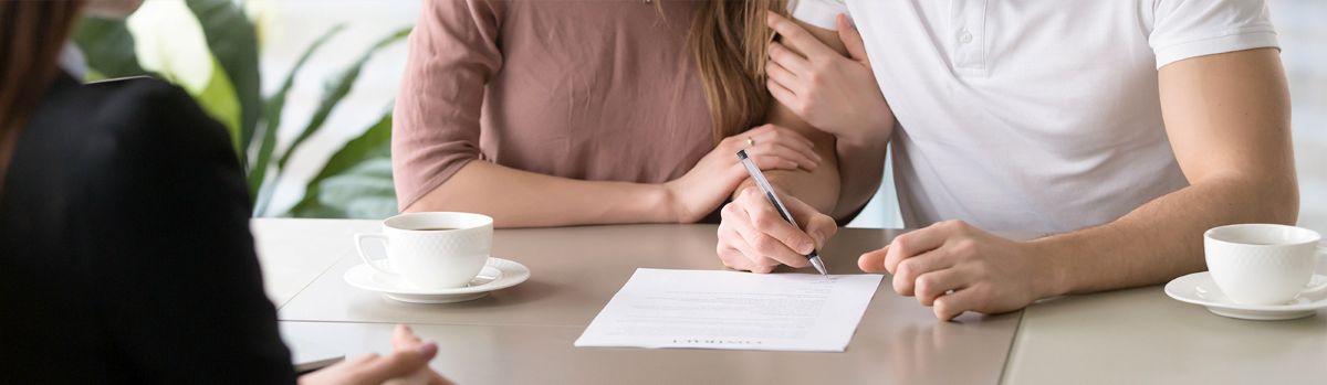 Couple signing paperwork.