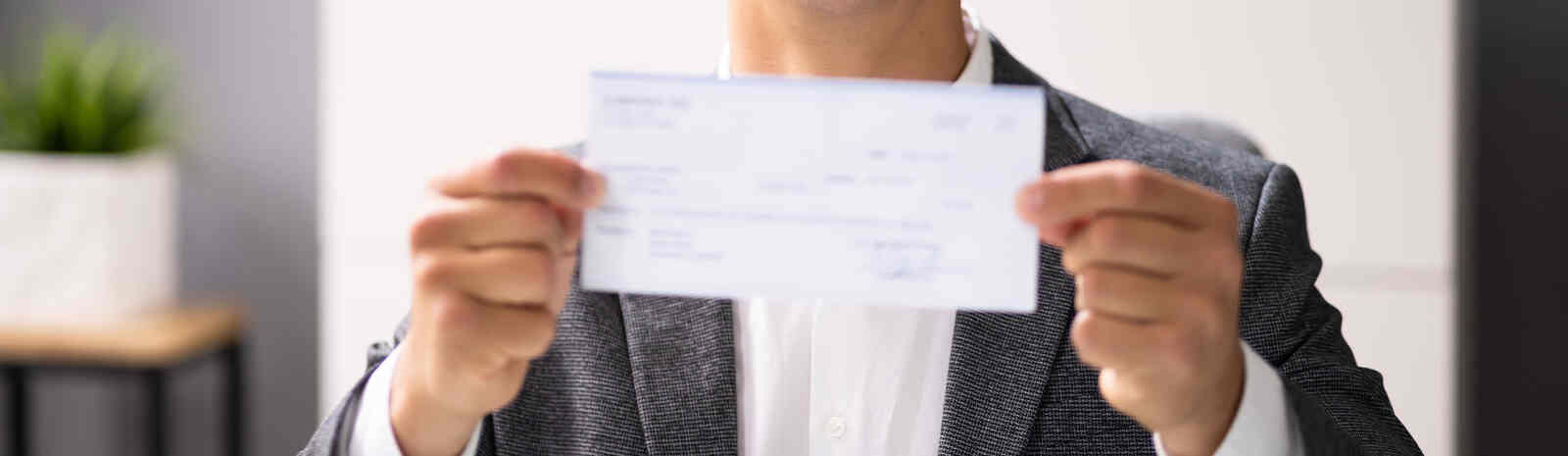 man holds up a check