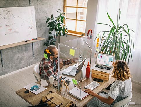 Business people sitting at desk with computers.